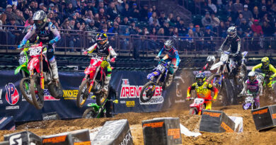 Arenacross riders hitting a series of jumps as an arena full of people looks on