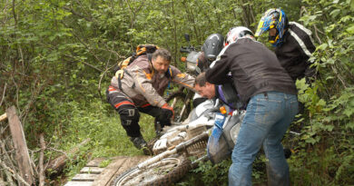 AMA Volunteer of the Year John Newton helping to pick up a motorcycle in the woods with a group of people