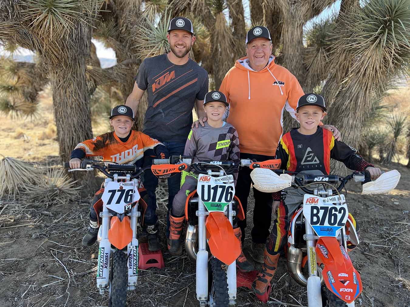 The Marshall family standing with the boys' dirt bikes 